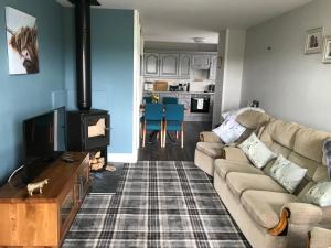 a living room with a couch and a stove at Sea view cottage in Allonby