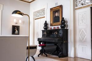 um piano preto numa sala com um candeeiro em Octant Lousa em Lousã