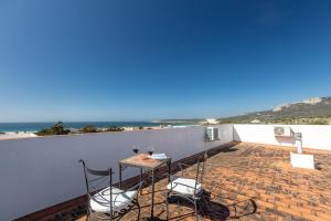 a balcony with a table and chairs and the ocean at APARTAMENTO LUZ A in Bolonia