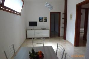 una sala da pranzo con tavolo e cesto di frutta di Galatone -Salento-, vicino a Gallipoli, super appartamento 6 persone a Galatone
