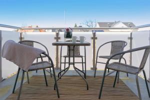 3 sedie e un tavolo sul balcone con tavolo e due letti di Ferienwohnung Bug a Zinnowitz