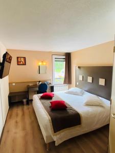 a hotel room with a large bed with red pillows at Atoll Hotel Logis Angers, Beaucouzé in Beaucouzé