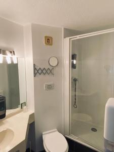 uma casa de banho com um chuveiro, um WC e um lavatório. em Atoll Hotel Logis Angers, Beaucouzé em Beaucouzé