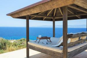 a bed in a pavilion with the ocean in the background at Cap Rocat, a Small Luxury Hotel of the World in Cala Blava