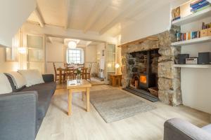 a living room with a couch and a fireplace at Porthgwidden Cottage in Uny Lelant