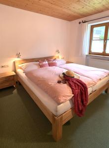 a bedroom with a large bed with a hat on it at Haus Claudia Lipp in Bad Hindelang