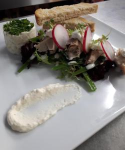 ハッセルトにあるB＆B ブルーンウィニングの白皿にサンドイッチと野菜を添えて