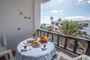 una mesa con un bol de fruta en el balcón en Casa Coral with sea views & AC, en Puerto del Carmen