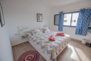un dormitorio con una cama con dos animales de peluche en Casa Coral with sea views & AC, en Puerto del Carmen
