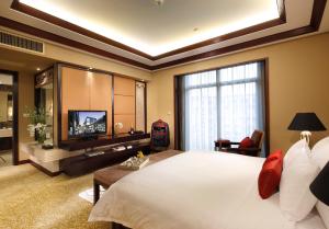 a large bedroom with a large bed and a television at Dong Fang Hotel Guangzhou in Guangzhou