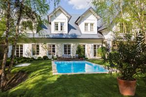 a house with a swimming pool in the yard at Dwór Złotopolska Dolina Mansion House in Trębki
