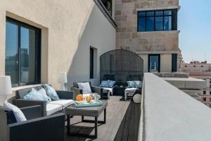 a balcony with furniture and a fireplace on a building at Vincci Capitol in Madrid