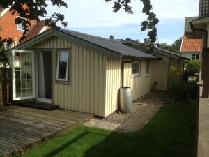 una pequeña casa con terraza y patio en stuga skrea strand en Falkenberg