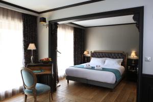 Habitación de hotel con cama y silla en Hôtel Villa-Lamartine, en Arcachon