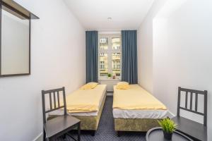2 łóżka w małym pokoju z oknem w obiekcie Za Zielonymi Drzwiami w mieście Sopot