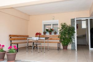 a patio with a table and chairs and potted plants at Μpasias Apartments in Paralia Katerinis