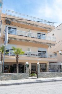 duży budynek z palmami przed nim w obiekcie Μpasias Apartments w Paralii Katerinis