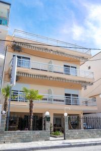 a building with palm trees in front of it at Μpasias Apartments in Paralia Katerinis