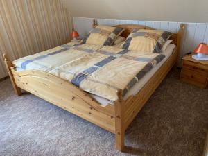 ein Bett mit einem Holzrahmen in einem Schlafzimmer in der Unterkunft Ferienwohnung Duensing in Neudorf