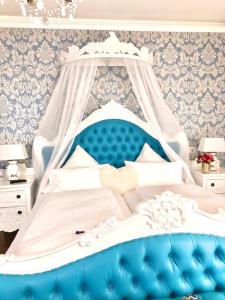 ein Bett mit einem blauen und weißen Baldachin in einem Zimmer in der Unterkunft Boutiquehotel Villa Rosenhof in Badenweiler
