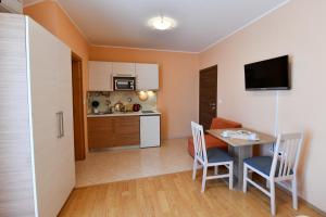 Apartments Vila Miranda في فوديس: مطبخ صغير وغرفة طعام مع طاولة وكراسي