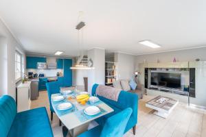 a dining room and living room with blue chairs and a table at Ferienhaus Seeblick in Binz