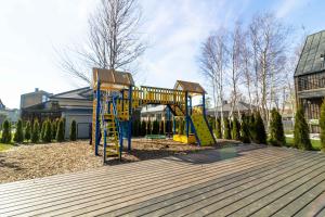a playground with a slide in a yard at Green Shine Apartment, By Cohost in Palanga
