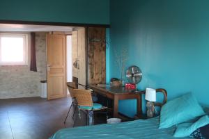 1 dormitorio con cama, escritorio y mesa en tempepailla, en Roynac
