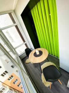 a table and chairs in a room with green curtains at Belvederska apartment 3 in Ivano-Frankivsʼk