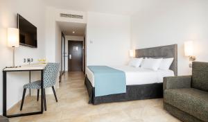a hotel room with a bed and a desk and a chair at Ilunion Calas de Conil in Conil de la Frontera