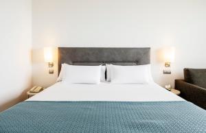 a bedroom with a large bed and a couch at Ilunion Calas de Conil in Conil de la Frontera