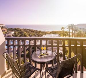 a table and chairs on a balcony with the ocean at Ilunion Calas de Conil in Conil de la Frontera