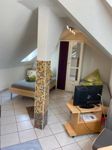 a living room with a column with a tv and a couch at Ferienwohnungen Rehn in Dresden