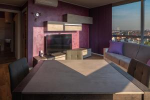 a living room with a table and a couch and a television at Crystal Tower M&M in Treviolo