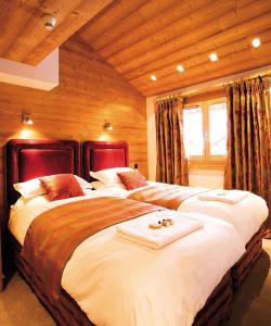twee bedden in een kamer met houten wanden bij Valdez Suite in Morzine