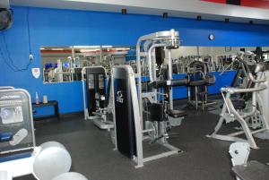 une salle de sport avec plusieurs machines à bande de roulement et un mur bleu dans l'établissement Days Inn by Wyndham Dyersburg, à Dyersburg