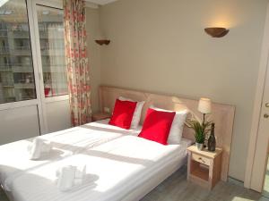 a bedroom with a large white bed with red pillows at Value Stay Blankenberge in Blankenberge