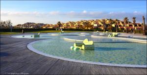 a playground with chairs in the water in a park at Studio Nefs des Sables in Leucate