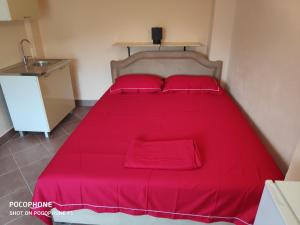 a red bed in a small room with a sink at Apartman Pavle 2 in Virpazar