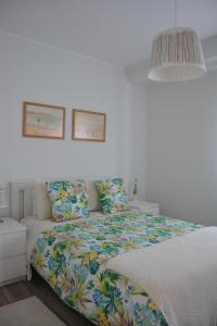 ポボア・デ・バルジンにあるCasa da Avenidaのベッドルーム1室(カラフルな掛け布団付きのベッド1台付)