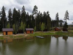 een groep hutten naast een meer bij Metsjärve kämping in Puskaru