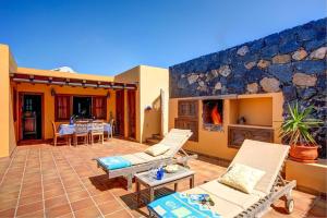 a patio with chairs and tables on a house at CASA ACEQUIA in Tinajo