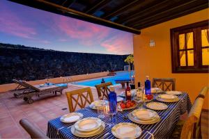 a dining room with a table and a view of a pool at CASA ACEQUIA in Tinajo