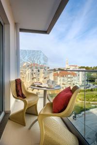 uma varanda com uma mesa e cadeiras e uma grande janela em Serra d'Aire Boutique Hotel - SA Hotels em Fátima