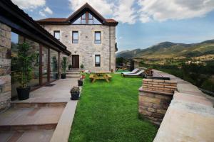 a house with a yard with a green lawn at El Balcon De La Lomba in La Lomba