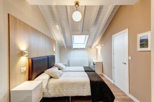 1 dormitorio con 1 cama y tragaluz en El Balcon De La Lomba, en La Lomba