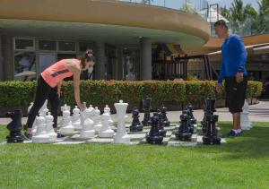 a woman playing a game of chess with a man at Sunset Plaza Beach Resort Puerto Vallarta All Inclusive in Puerto Vallarta