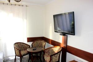 Camera con tavolo, sedie e TV a schermo piatto. di Pokoje Gościnne Kowalscy a Jawor