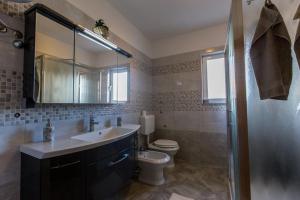 un bagno con lavandino, WC e specchio di Guest House Casa Mia - Rooms & Apartments a Rovigno (Rovinj) Altre 56 foto