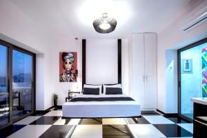 a bedroom with a bed and a painting on the wall at Majestic Penthouse in the heart of Patra in Patra